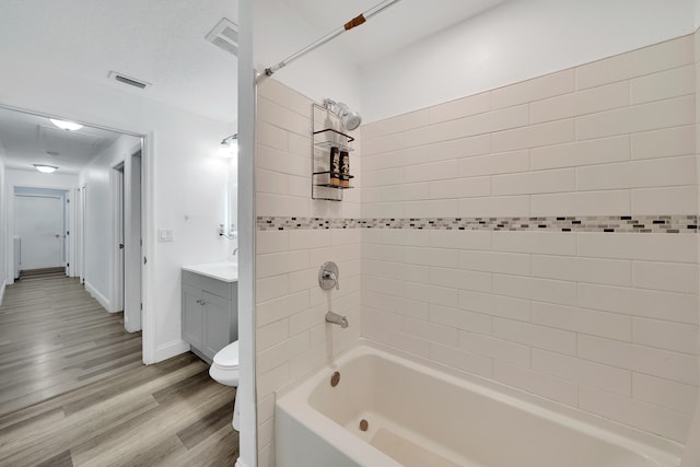 full bathroom with wood-type flooring, vanity, toilet, and tiled shower / bath