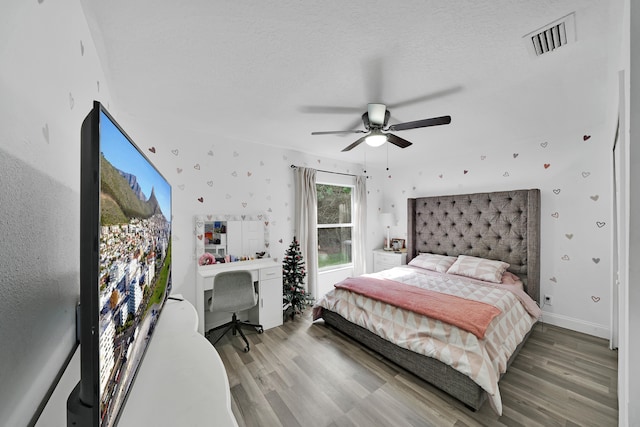 bedroom featuring a textured ceiling, hardwood / wood-style floors, and ceiling fan