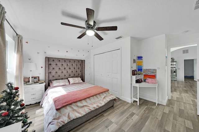 bedroom featuring light wood-type flooring, ceiling fan, and a closet