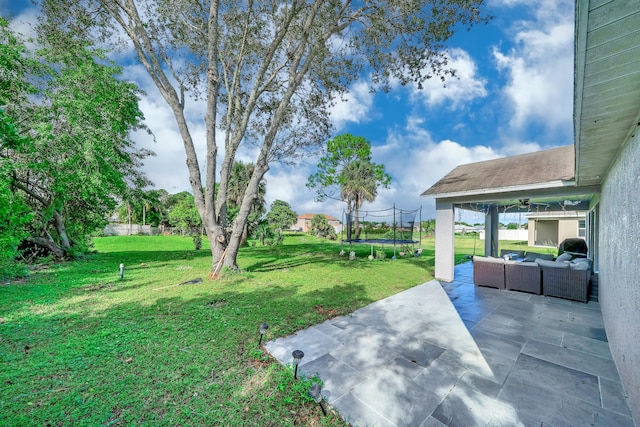 view of yard with outdoor lounge area, a trampoline, and a patio area