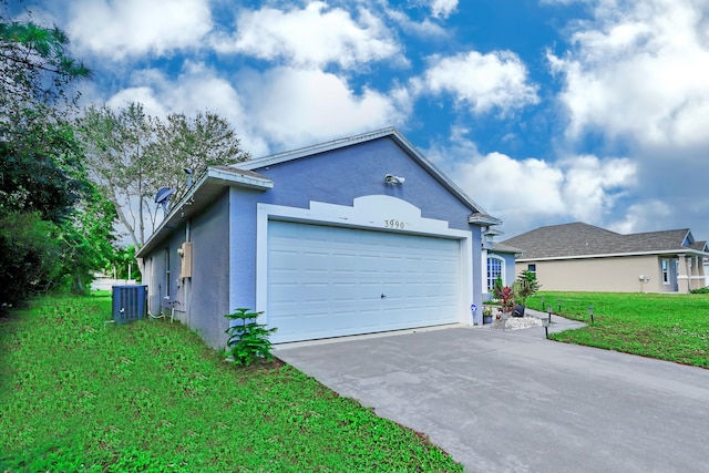 exterior space featuring a front lawn, a garage, and central AC