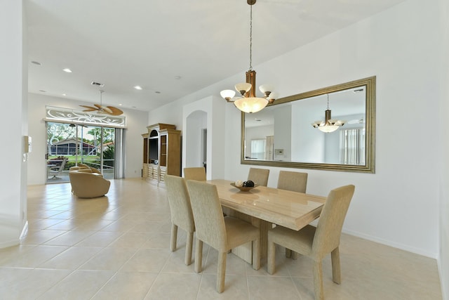 tiled dining space featuring ceiling fan with notable chandelier