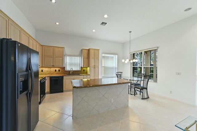 kitchen with black appliances, a kitchen island, light tile patterned floors, and sink