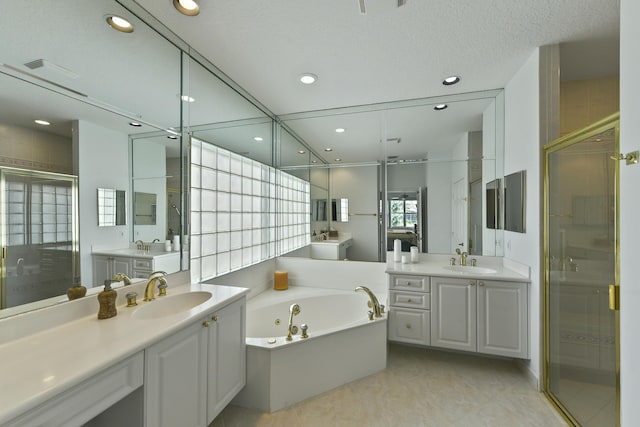 bathroom with tile patterned floors, vanity, a textured ceiling, and shower with separate bathtub