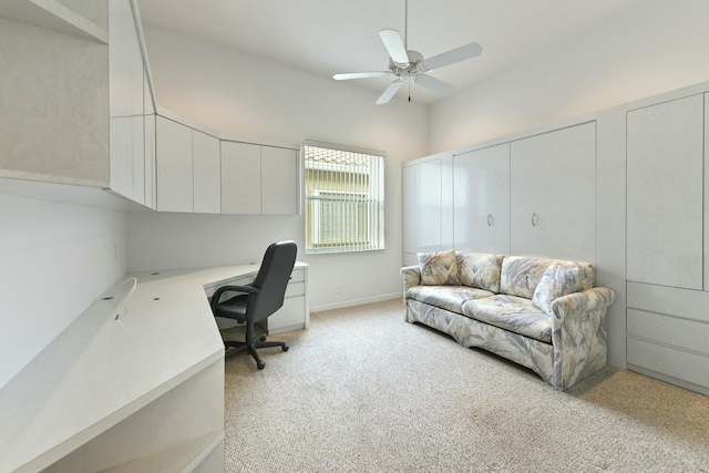 carpeted office with ceiling fan and built in desk