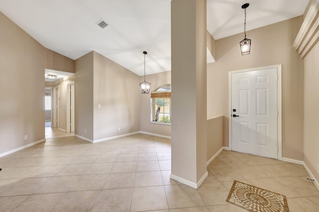 foyer featuring light tile patterned floors and high vaulted ceiling