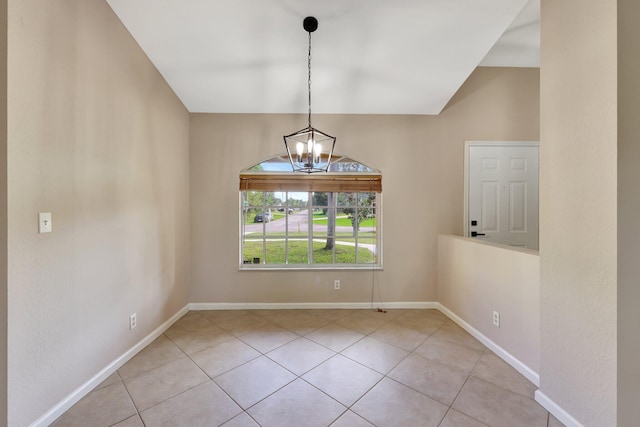 empty room with light tile patterned floors and an inviting chandelier