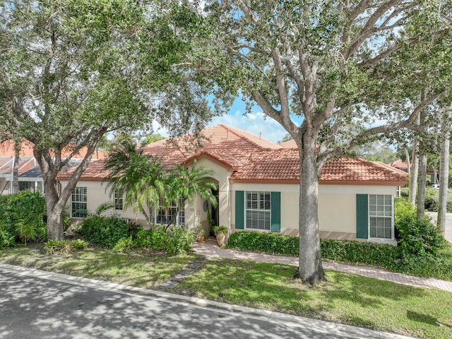 mediterranean / spanish-style home with a front lawn