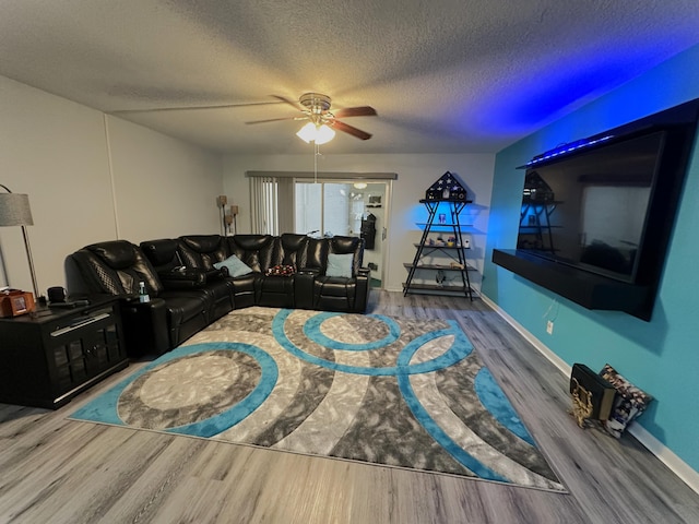 living room featuring hardwood / wood-style floors, a textured ceiling, and ceiling fan