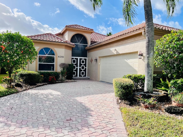 mediterranean / spanish-style home with a garage