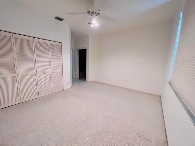 unfurnished bedroom with ceiling fan and a closet