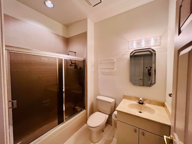 full bathroom featuring toilet, combined bath / shower with glass door, vanity, and tile patterned flooring