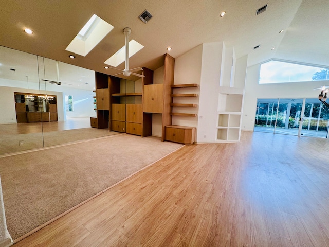 kitchen with black appliances, tasteful backsplash, light wood-type flooring, high vaulted ceiling, and sink