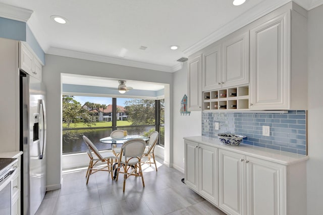 dining area with light tile patterned floors, a water view, ceiling fan, and ornamental molding