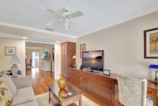 living room featuring ceiling fan, crown molding, and light hardwood / wood-style flooring