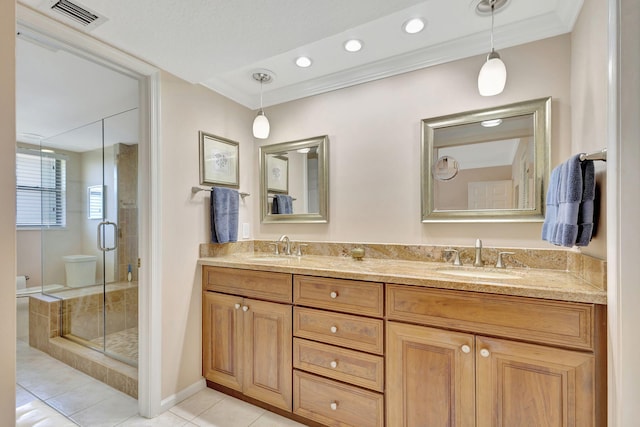 bathroom featuring vanity, tile patterned floors, a shower with shower door, and crown molding