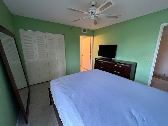 bedroom featuring a closet, light tile patterned floors, and ceiling fan