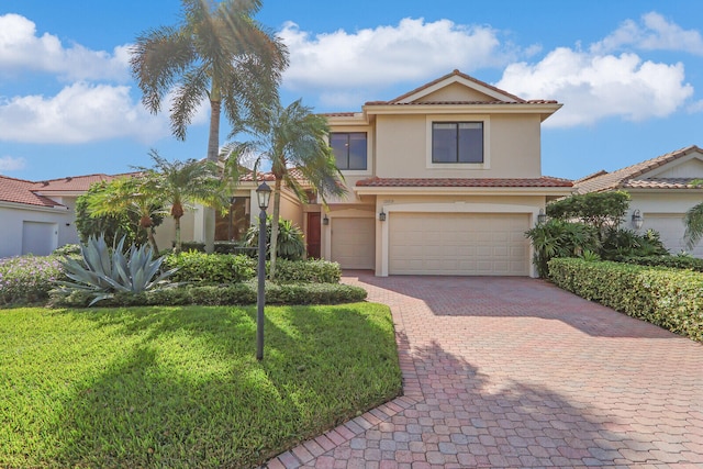 mediterranean / spanish house with a front lawn and a garage