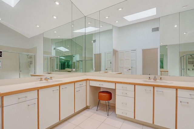 bathroom with tile patterned floors, high vaulted ceiling, vanity, a skylight, and walk in shower