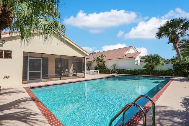 view of pool featuring a patio and a sunroom