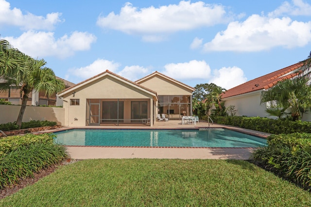 view of swimming pool with a lawn, a sunroom, and a patio area