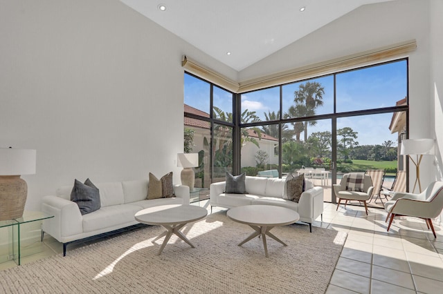 tiled living room featuring high vaulted ceiling and a healthy amount of sunlight