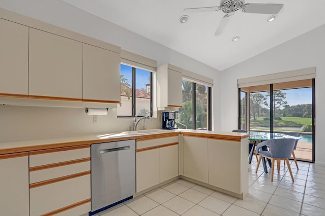 kitchen with light tile patterned floors, sink, vaulted ceiling, stainless steel dishwasher, and ceiling fan