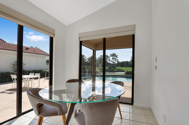 dining space featuring light tile patterned floors and lofted ceiling