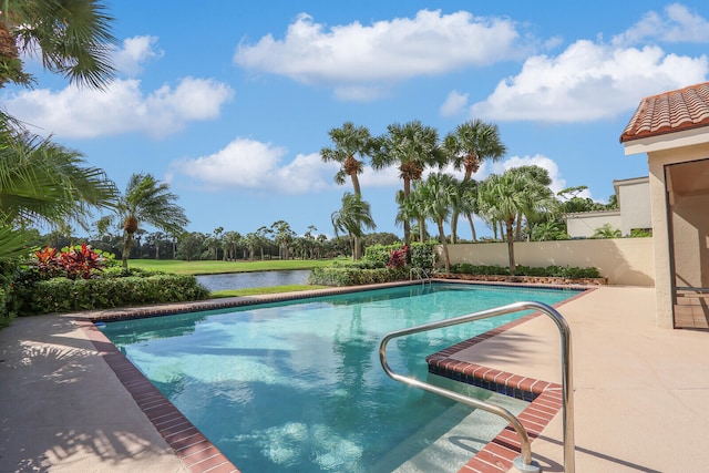 view of pool featuring a water view and a patio area