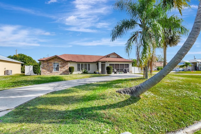 single story home with a front yard and central air condition unit