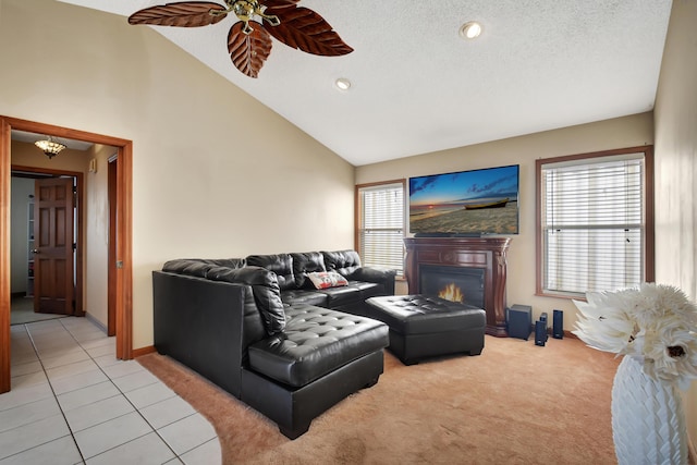 tiled living room featuring ceiling fan, high vaulted ceiling, and a textured ceiling