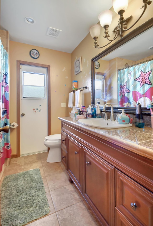 bathroom with tile patterned flooring, vanity, and toilet