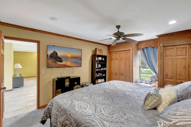 tiled bedroom with a textured ceiling, a closet, ceiling fan, and crown molding