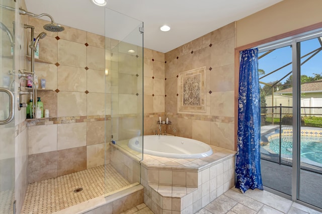 bathroom featuring plus walk in shower and tile walls