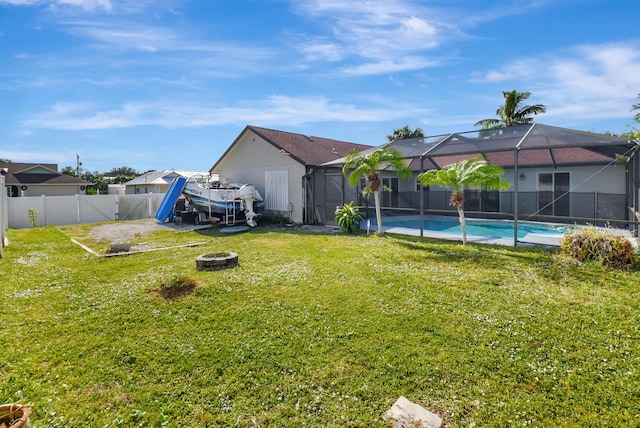 view of yard with a lanai, a fenced in pool, and an outdoor fire pit