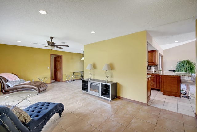 tiled living room with ceiling fan and a textured ceiling