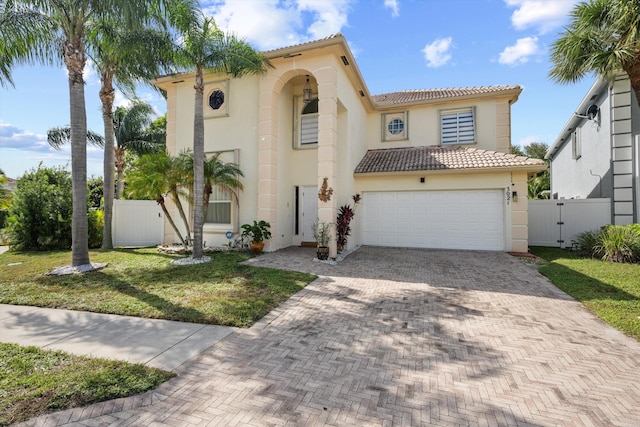 mediterranean / spanish house with a garage and a front lawn