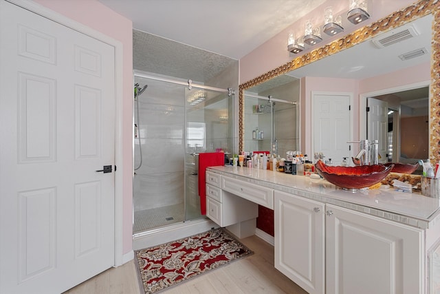 bathroom featuring vanity, a shower with door, and hardwood / wood-style floors