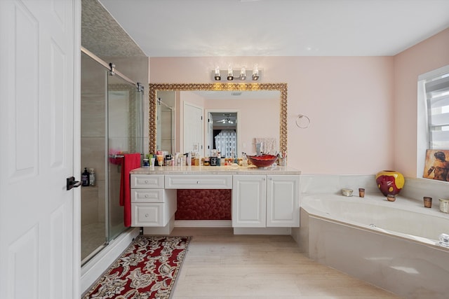 bathroom featuring vanity, shower with separate bathtub, and hardwood / wood-style floors