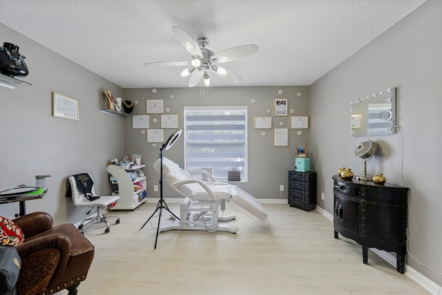 bedroom with ceiling fan, light hardwood / wood-style floors, and a textured ceiling