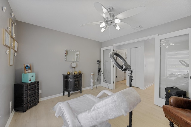 exercise room featuring light hardwood / wood-style floors and ceiling fan