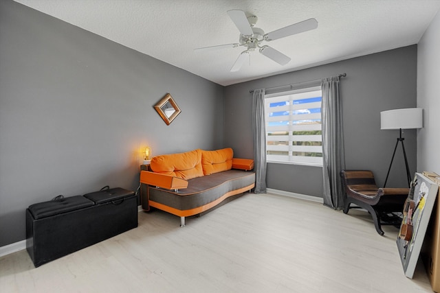 sitting room with ceiling fan, a textured ceiling, and light hardwood / wood-style floors