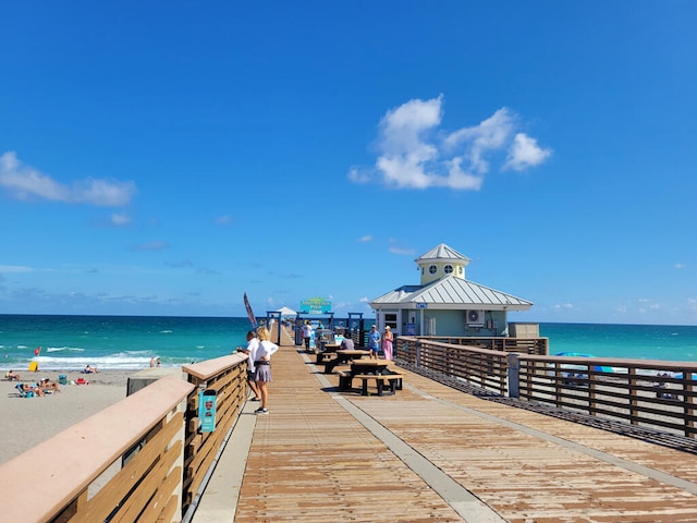 dock area featuring a water view and a view of the beach