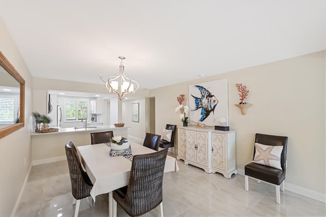 dining area featuring a chandelier and sink