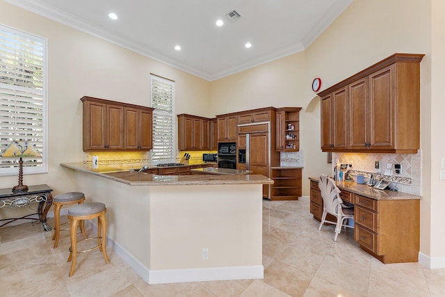 kitchen with stone counters, black appliances, decorative backsplash, ornamental molding, and kitchen peninsula