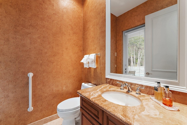 bathroom with tile patterned flooring, vanity, and toilet