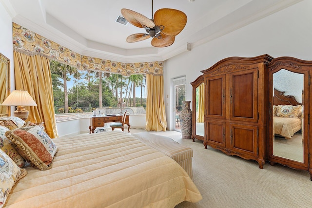 carpeted bedroom featuring ceiling fan, a raised ceiling, and crown molding