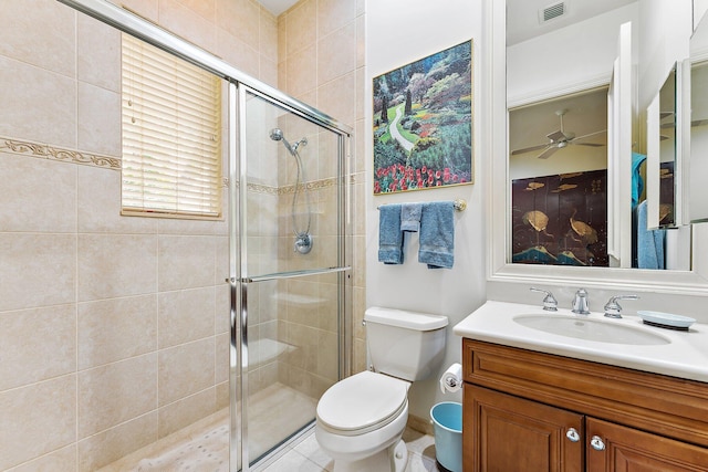 bathroom featuring ceiling fan, toilet, a shower with shower door, and vanity