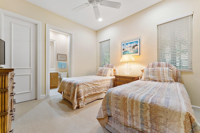 bedroom with connected bathroom, ceiling fan, and light colored carpet