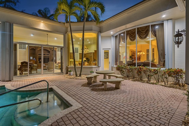 back house at night featuring a patio